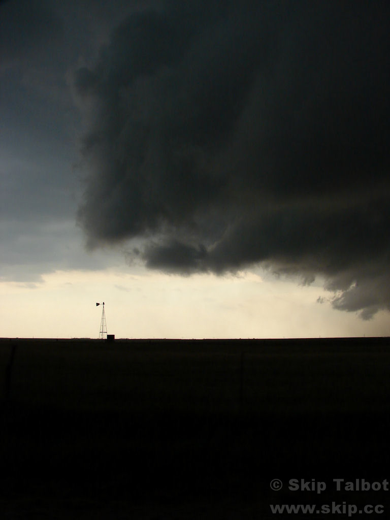 A windmill about to be overtaken by the gust front of a severe thunderstorm