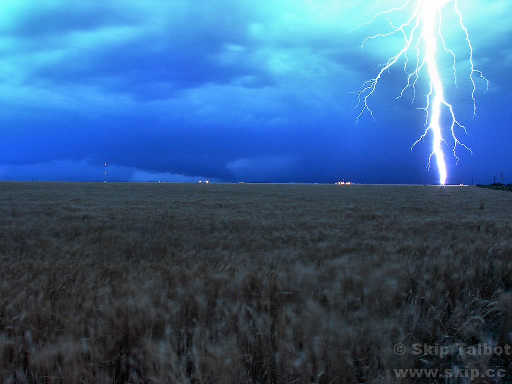 A bolt of cloud to ground lightning strikes ahead of a high-precipitation supercell