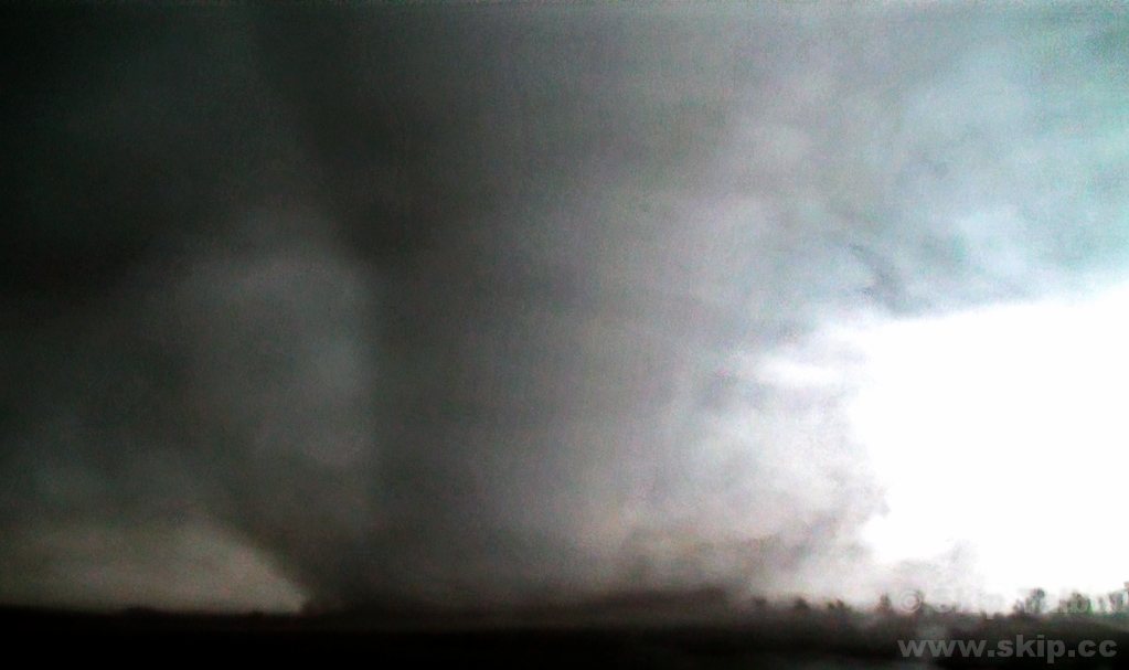 A powerful tornado churns through a nearby field